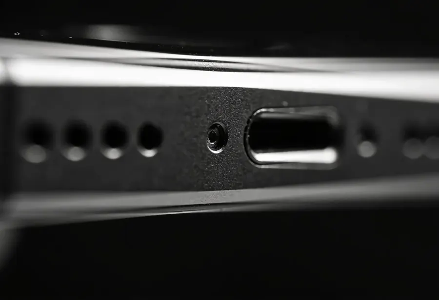 Borda de baixo de um celular com a grade do alto falante e o microfone