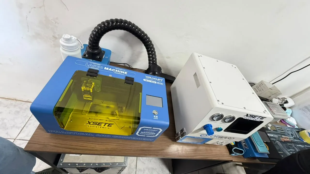 Máquina a laser azul e equipamento branco com a marca XSETE sobre a mesa de trabalho